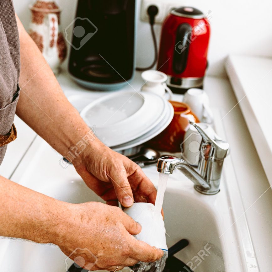205612439-middle-aged-man-muscular-build-wearing-brown-kitchen-apron-washing-dishes-in-kitchen-kitchen-concept
