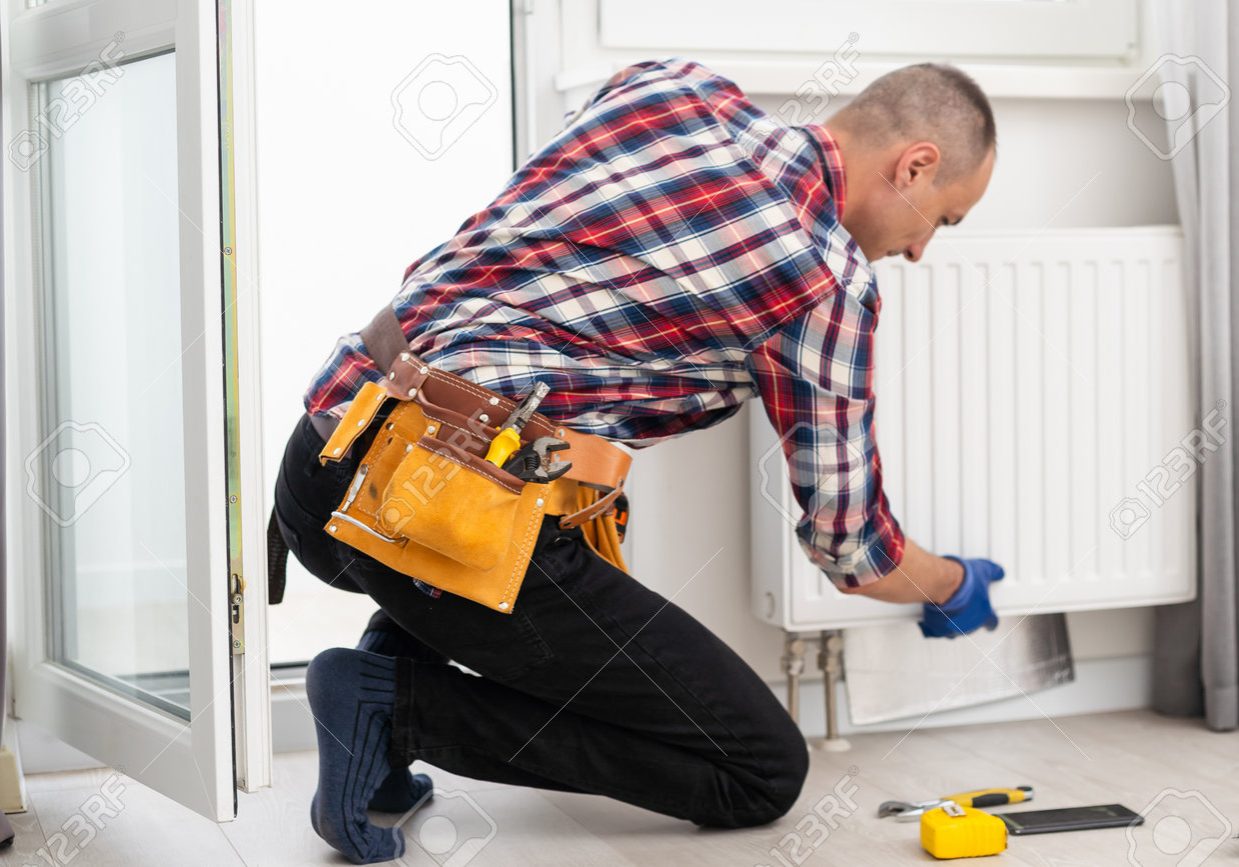 215333051-plumber-at-work-installing-water-heating-radiator